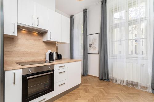 a kitchen with white cabinets and a window at Fancy Home Prague #2 in Prague