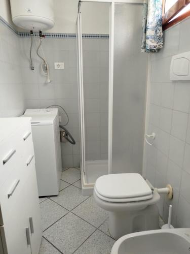 a white bathroom with a toilet and a shower at Oasi Boungaville in Porto San Paolo