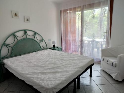 a bedroom with a bed and a couch and a window at Oasi Boungaville in Porto San Paolo