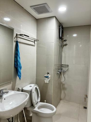 a bathroom with a toilet and a sink and a shower at Apartment Podomoro Medan in Medan