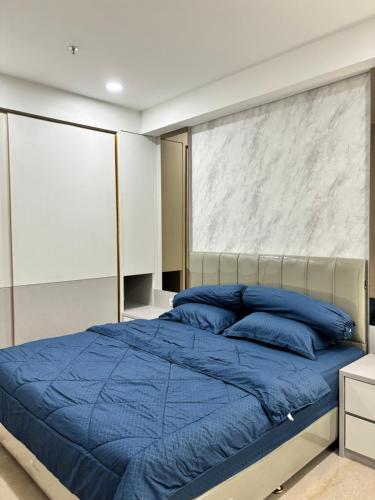 a bedroom with a bed with blue pillows at Apartment Podomoro Medan in Medan