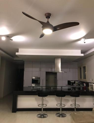 a ceiling fan in a living room with a kitchen at Hacienda Bay, North Coast in El Alamein