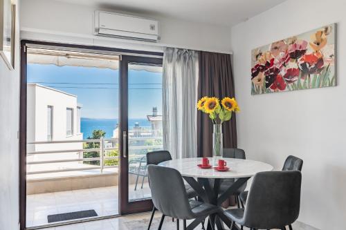 een eetkamer met een tafel en stoelen en een balkon bij Enyoj Marjan, Beaches and View in Split