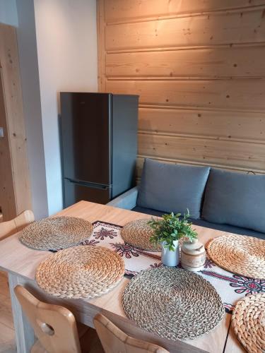a table with four plates on it with a refrigerator at Domeczek Góralski Zakopane in Zakopane