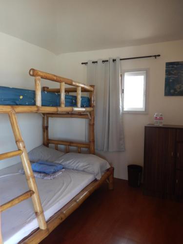 a bedroom with two bunk beds and a window at Sunset Garden Lambug Badian in Badian