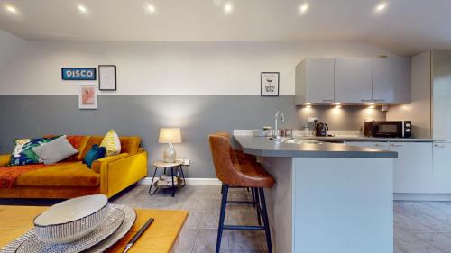 cocina y sala de estar con sofá amarillo en Central 2 Bed Flat with Parking en Cardiff