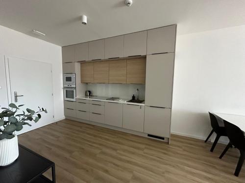 a kitchen with white cabinets and a table in a room at Hotel Kapitol in Most