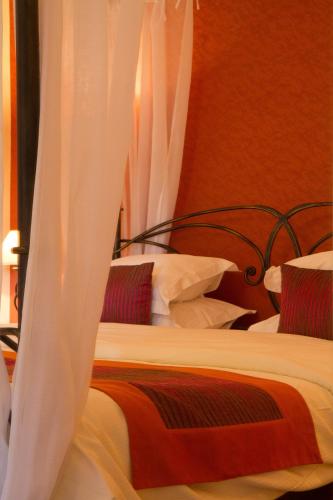 two beds with white curtains in a bedroom at Hotel Kieffer in Itterswiller