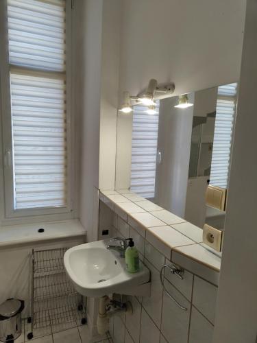 uma casa de banho branca com um lavatório e um espelho em Apartament Centrum em Kalisz