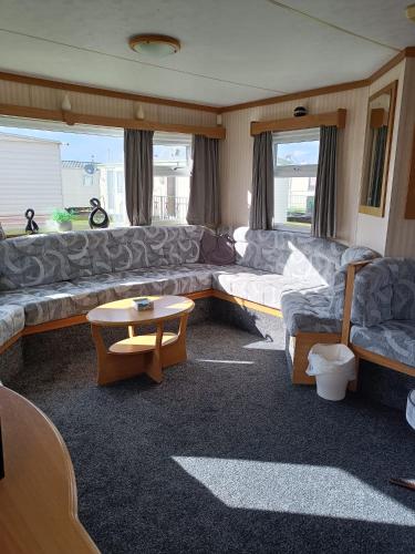 a living room with a couch and a table at 8 Berth Sealands (Highbury) in Ingoldmells