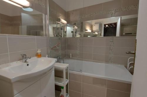 une salle de bain avec un lavabo et une baignoire dans l'établissement La Brise Normande centre de ville de Honfleur, à Honfleur