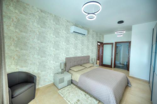 a bedroom with a bed and a chair at Fort Cambridge Apartments in Sliema