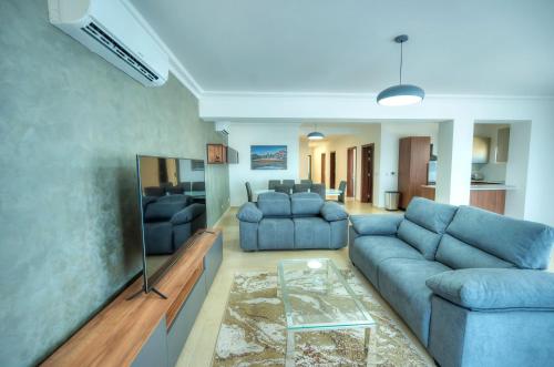 a living room with a blue couch and a table at Fort Cambridge Apartments in Sliema