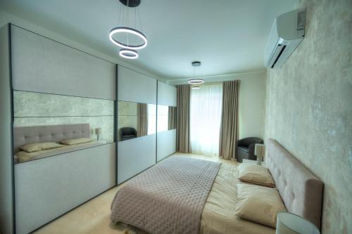 a bedroom with a bed and a wall with mirrors at Fort Cambridge Apartments in Sliema