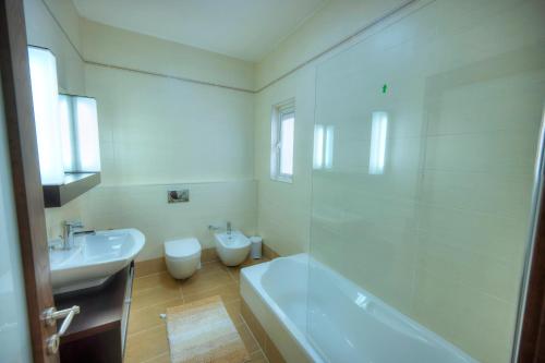 a bathroom with a tub and a sink and a toilet at Fort Cambridge Apartments in Sliema
