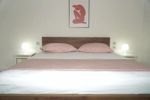 una camera con un letto con due cuscini rosa di Elegant central apartment a Heraklion