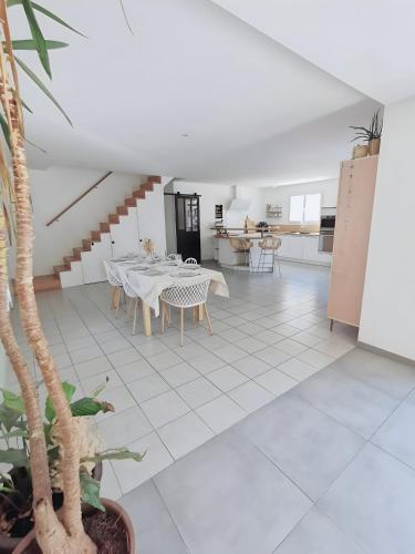 une salle à manger avec un sol carrelé blanc dans l'établissement La Cigale - Maison (8 pers) au Lac de Lacanau, à Lacanau