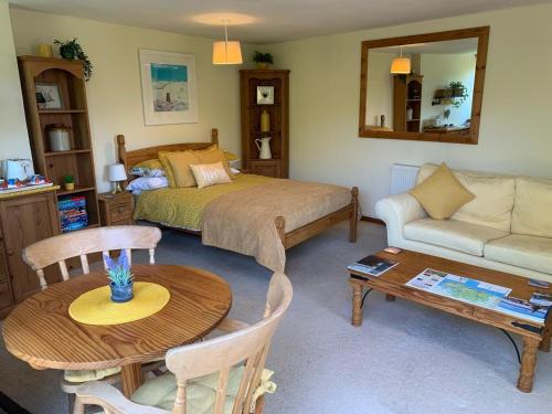 The Cottage Studio في وول: غرفة معيشة مع سرير وطاولة
