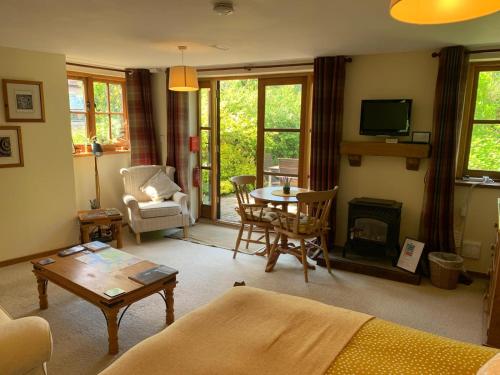 a living room with a couch and a table at The Cottage Studio in Wool