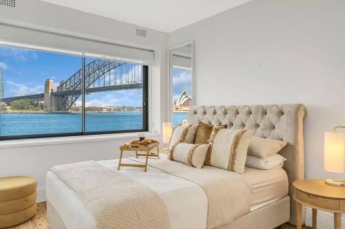 a bedroom with a bed with a view of a bridge at Kirribilli Kanangra in Sydney