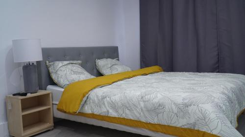 - une chambre avec un lit doté d'une couette et d'oreillers jaunes dans l'établissement charming studio saint martin, à Pontoise