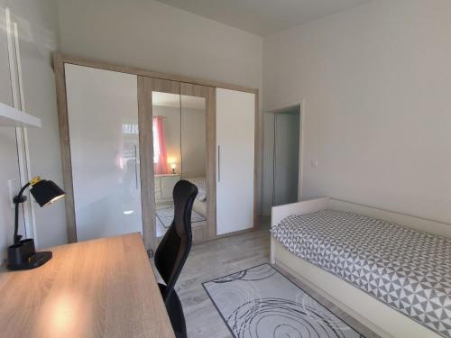 a bedroom with a bed and a table and a mirror at FeWo Südertoft - gemütliche Unterkunft für bis zu 3 Personen in Wallsbüll