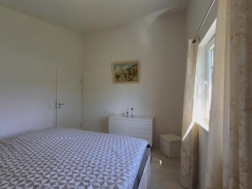 a bedroom with a bed and a dresser and a window at FeWo Südertoft - gemütliche Unterkunft für bis zu 3 Personen in Wallsbüll
