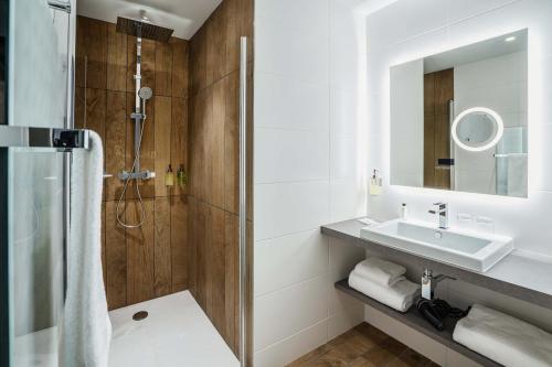 uma casa de banho com um lavatório e um chuveiro em Best Western Premier Hotel de la Cite Royale em Loches