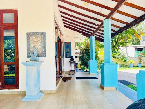 Lake Face Hotel في أنورادابورا: مدخل منزل به اعمدة زرقاء