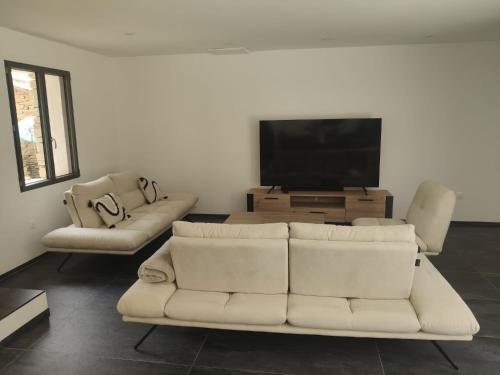 - un salon avec deux canapés blancs et une télévision à écran plat dans l'établissement Villa Soleil, à Gordes