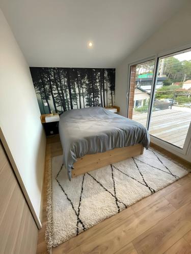 une chambre avec un lit et une grande fenêtre dans l'établissement La Cigale - Maison (8 pers) au Lac de Lacanau, à Lacanau