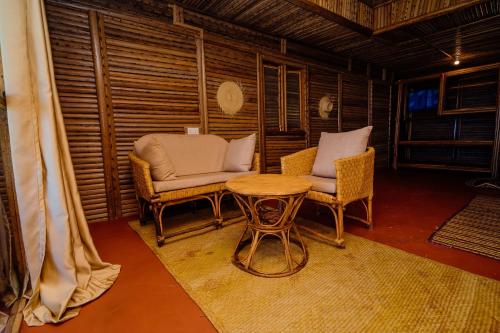 a living room with two chairs and a table at Maisara Mafia Beach Lodge in Kilindoni