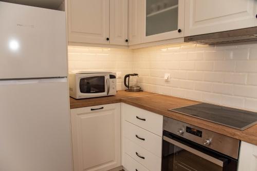 a kitchen with white cabinets and a microwave at Amalia Complex in Nisakion