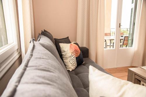 a gray couch in a living room with pillows at Amalia Complex in Nisakion