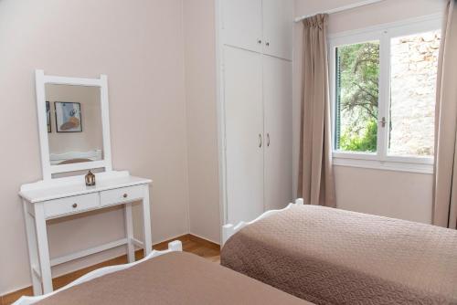 a bedroom with two beds and a mirror and a window at Amalia Complex in Nisakion
