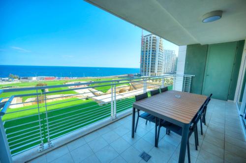 a balcony with a table and a view of the ocean at Fort Cambridge Apartments in Sliema