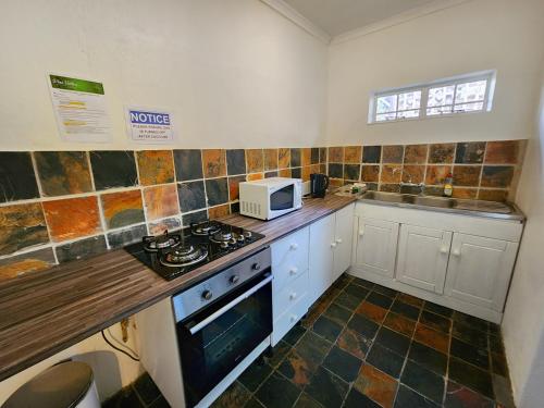 a kitchen with a stove and a microwave at Pine Valley in Lanseria