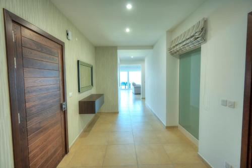 a hallway with a wooden door and a hallway with a couch at Fort Cambridge Apartments in Sliema