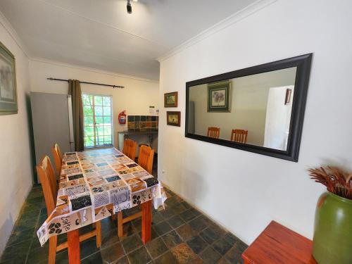 a dining room with a table and a mirror at Pine Valley in Lanseria