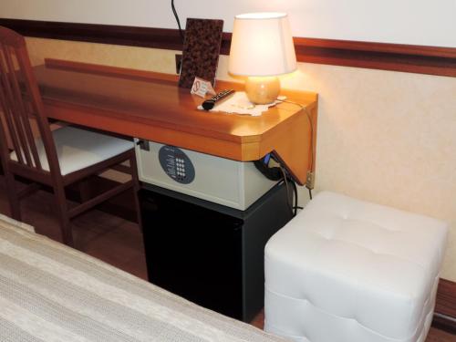 a desk with a lamp and a chair next to a bed at Hotel Signa in Perugia