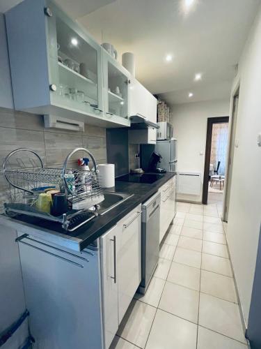 - une cuisine avec des placards bleus et blancs et un évier dans l'établissement Thé Pékin, à Belfort