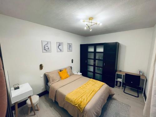 - une chambre avec un lit et une couette jaune dans l'établissement Thé Pékin, à Belfort