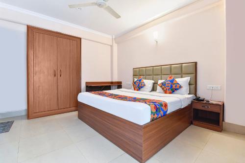 a bedroom with a large bed and a wooden cabinet at FabExpress Central Plaza in Dehradun