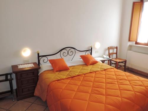 a bedroom with a bed with orange pillows on it at Hotel Signa in Perugia