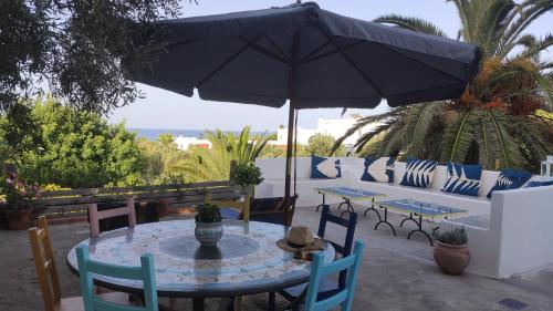 a table and chairs with an umbrella on a patio at La Casa di Nonna Ida in Stromboli