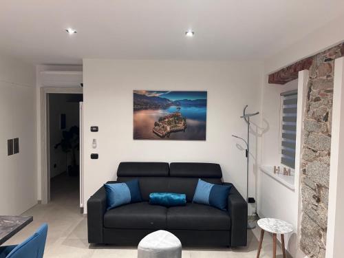 a living room with a black couch and a painting at Lakes and Mountains Magic Holiday House in Omegna
