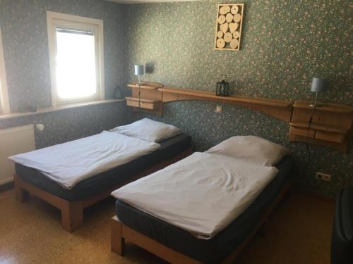 two twin beds in a room with a wall at Ferienzimmer Saatmann in Amorbach