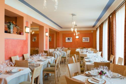 a dining room with white tables and chairs at Hotel Villa Mare in Altavilla Milicia