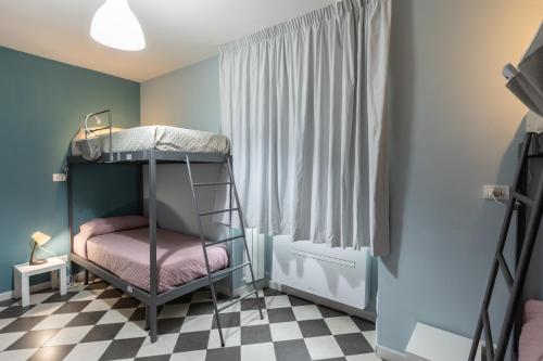 a bunk bed in a room with a checkered floor at HOSTEL PORTICI in Portici