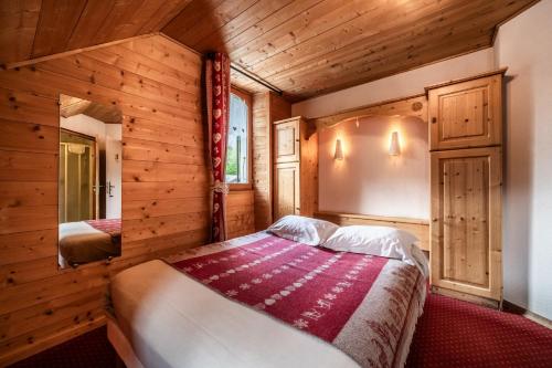 a bedroom with a bed in a wooden room at L' Abbaye in Abondance